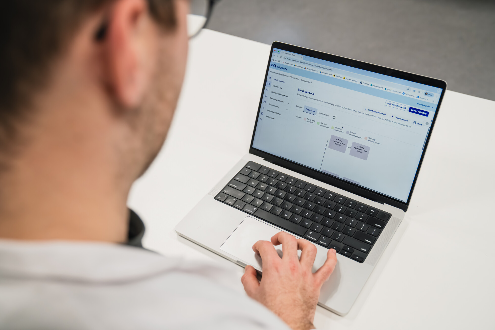 in Arzt in einer Klinik ruft strukturierte Studiendaten einer Patientin ab, die sich in ihrer häuslichen Umgebung befindet. Über eine digitale Plattform überwacht er ihre Gesundheitsparameter, erhält Reports und kommuniziert per Push-Nachricht direkt mit ihr.